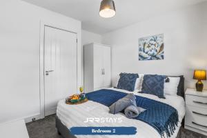a bedroom with a bed with blue and white sheets at Wolverhampton - Amazing 3 Bedroom, Sleeps 6, Wi-Fi - JRR Stays in Fallings Park