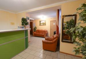 una sala de espera con 2 sillas y un espejo en Viktoria Hotel, en Cherepovets
