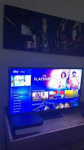 a flat screen tv sitting on top of a shelf at Spacious Double Room in Leicester
