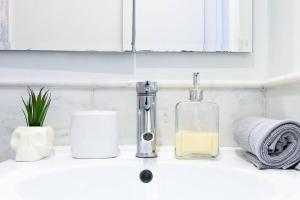 um lavatório de casa de banho com um dispensador de sabão em 62-3B Studio Prime UES Walk to Central Park em Nova York