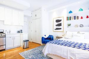 a white bedroom with a bed and a kitchen at 62-3B Studio Prime UES Walk to Central Park in New York