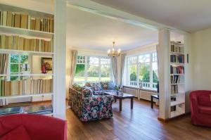 a living room with a couch and bookshelves at Reetdachhaus mit großem Garten und Kamin in Marlow