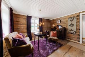 uma sala de estar com paredes de madeira e uma mesa e cadeiras em Flatheim em Viksdalen