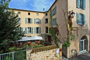 a building with a restaurant in front of it at Hôtel Le Quatorze in Figeac