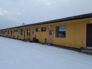 een rij gele gebouwen met sneeuw eromheen bij Pieksämäellä saunallinen rivitalokaksio in Pieksamaki