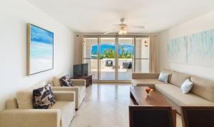 a living room with two couches and a tv at New Listing La Vista Azul Spacious 1 Bedroom Condo in Turtle Cove