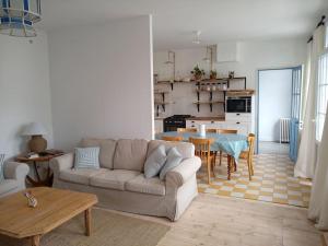ein Wohnzimmer mit einem Sofa und einem Tisch in der Unterkunft Rochefort, Charentaise 3 à 7 personnes, 3 étoiles in Rochefort