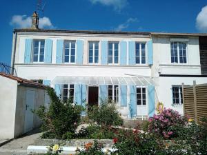 ein weißes Haus mit blauen Fensterläden darauf in der Unterkunft Rochefort, Charentaise 3 à 7 personnes, 3 étoiles in Rochefort