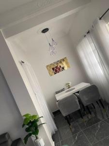 a white dining room with a table and chairs at Superbe appartement cosy-chic in Cotonou