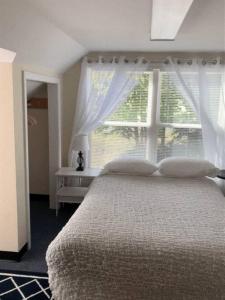 a bedroom with a large bed and a window at North Getaway Cottage in Williamstown