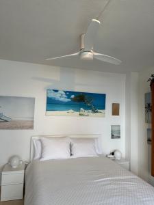 トレモリノスにあるApartamentos La Roca Costa del Solのベッドルーム1室(ベッド1台、シーリングファン付)