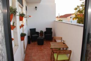 a small balcony with chairs and a table and chairs at Casa Borges in Charneca