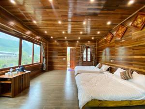 sypialnia z 2 łóżkami w pokoju z drewnianymi ścianami w obiekcie Lan Rừng Homestay w mieście Lũng Niêo