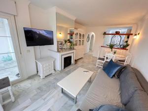 ein Wohnzimmer mit einem Sofa und einem Kamin in der Unterkunft El Mirador de Mijas Piscina y Parking gratis in Málaga