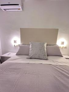 ein Schlafzimmer mit einem großen weißen Bett mit zwei Kissen in der Unterkunft El Mirador de Mijas Piscina y Parking gratis in Málaga