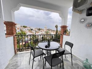 eine Terrasse mit einem Tisch und Stühlen auf dem Balkon in der Unterkunft El Mirador de Mijas Piscina y Parking gratis in Málaga