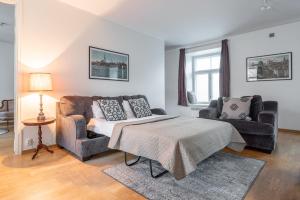 a bedroom with a bed and a couch and a chair at Old Town - Vana Viru Apartment in Tallinn