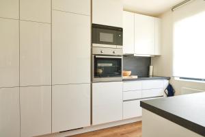 a kitchen with white cabinets and a microwave at Alpenrose in Obermaiselstein