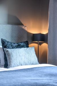 a bedroom with a bed with a pillow and a lamp at Quality Hotel Grand Royal in Narvik