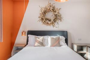 a bedroom with a bed with a wreath on the wall at Esperance - Brand New, luxury studio with parking in Bowness-on-Windermere