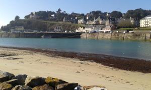 una playa con una gran masa de agua y casas en Proche port Centre village, en Barneville-Carteret