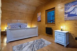Habitación con cama, escritorio y ventana. en TATRYSTAY RiverStone Chalets en Demanovska Dolina