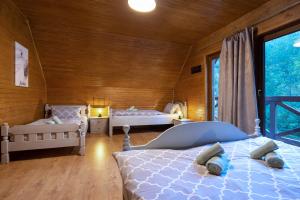 sypialnia z 2 łóżkami i dużym oknem w obiekcie TATRYSTAY RiverStone Chalets w Demianowskiej Dolinie