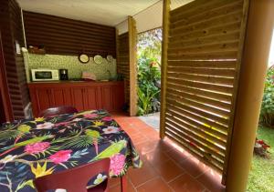 a bedroom with a bed and a kitchen in the background at LE DOMAINE DE LA VALLEE in Le Morne Rouge