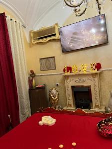 a room with a red table with a tv on the wall at B&B Sotto gli archi in Catania
