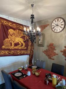 a dining room with a table and a clock on the wall at The Mountains in Cape Town