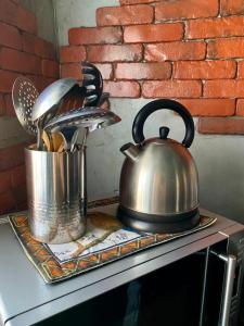 a tea kettle and pans on top of a stove at The Mountains in Cape Town