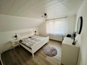 een slaapkamer met een bed, een tafel en een spiegel bij Ferienhaus Lotte in Detern