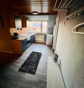 een kamer met een keuken met blauwe kasten en een tafel bij Ferienhaus Lotte in Detern