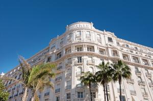 un grande edificio bianco con palme di fronte di Palais Miramar - Suite & G17 - Vue Mer - Croisette Emplacement Unique -20 Plage - WIFI - Clim a Cannes