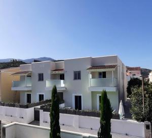a white building with trees in front of it at The Central Residence - Kassiopi Corfu Villas in Kassiopi