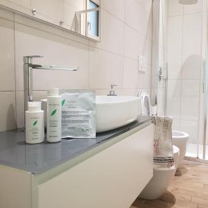 La salle de bains est pourvue d'un lavabo et d'un comptoir avec 2 produits. dans l'établissement LuxurySmart, à Misano Adriatico