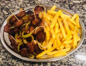 a plate of food with sausages and french fries at Bento palace hotel in Assis