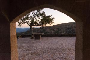 un arco con un árbol y un banco en una montaña en Casal dos Netos, en Penhas da Saúde