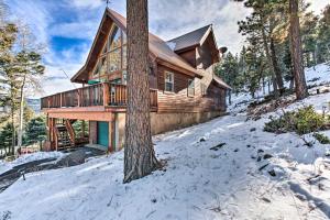 una cabaña de madera en el bosque en la nieve en Stunning Angel Fire Home 3 Mi to Ski Resort!, en Angel Fire