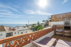 a balcony with chairs and a view of a city at Casa La Intemporal in Nerja