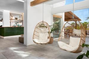 two swinging chairs in a room with a restaurant at Maya Beach Resort in Massa Lubrense