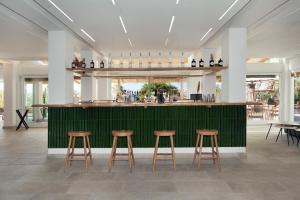 a bar in a restaurant with stools and a counter at Maya Beach Resort in Massa Lubrense