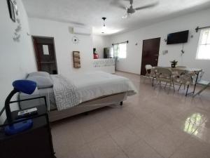 a bedroom with a bed and a table and chairs at Sisal Brisa de Mar in Sisal