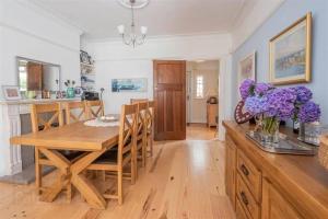 a kitchen and dining room with a table and purple flowers at Delightful Family Home in Lisburn