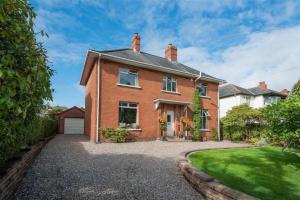 a red brick house with a driveway at Delightful Family Home in Lisburn