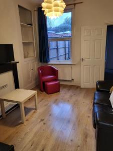 a living room with a couch and a red chair at Entire Flat city centre based. in Parkside