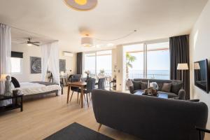 een woonkamer met een bank, een bed en een tafel bij Modern luxury beach Penthouse in La Herradura