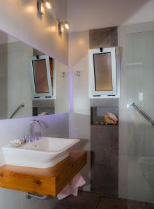 a bathroom with a sink and two mirrors at Finca del Rio - Casa de campo in Tunuyán