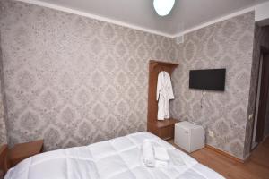 een slaapkamer met een bed en een tv aan de muur bij HOTEL SAMEGRELO in Zugdidi