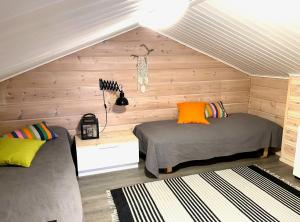 Duas camas num quarto com paredes de madeira em Vuosselin Kuura (2 mh + tilava parvi) em Kuusamo